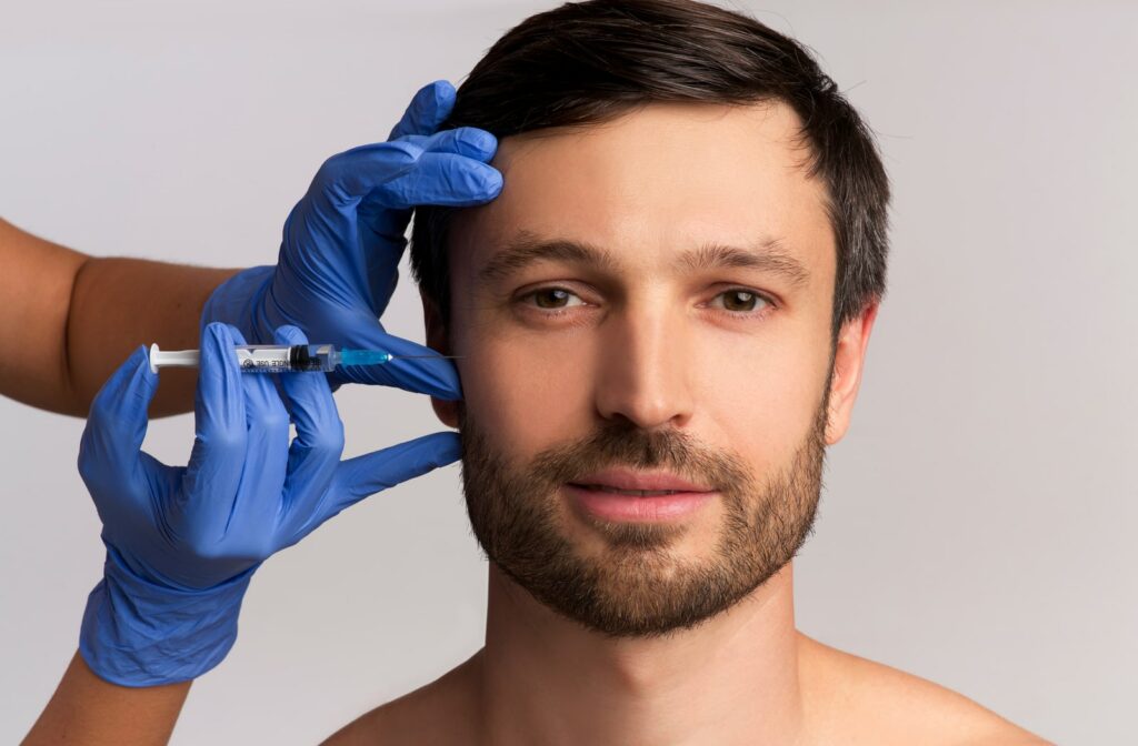 A man receiving a dermal filler treatment on his face